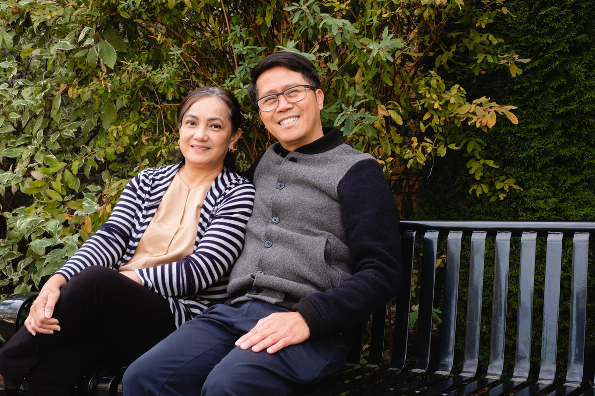 couple smile sitting on park bench