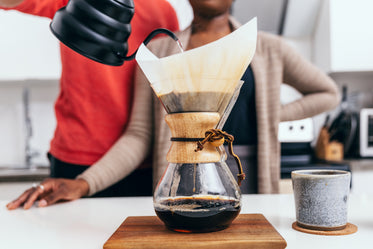 couple stand together pouring coffee