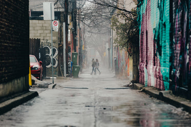 couple walking through graffiti alley