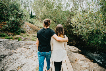 couple walks together through a forest scene