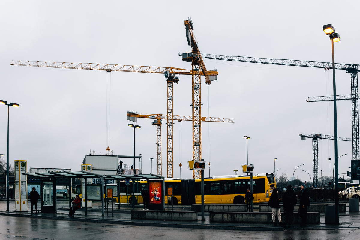 cranes hover over buses