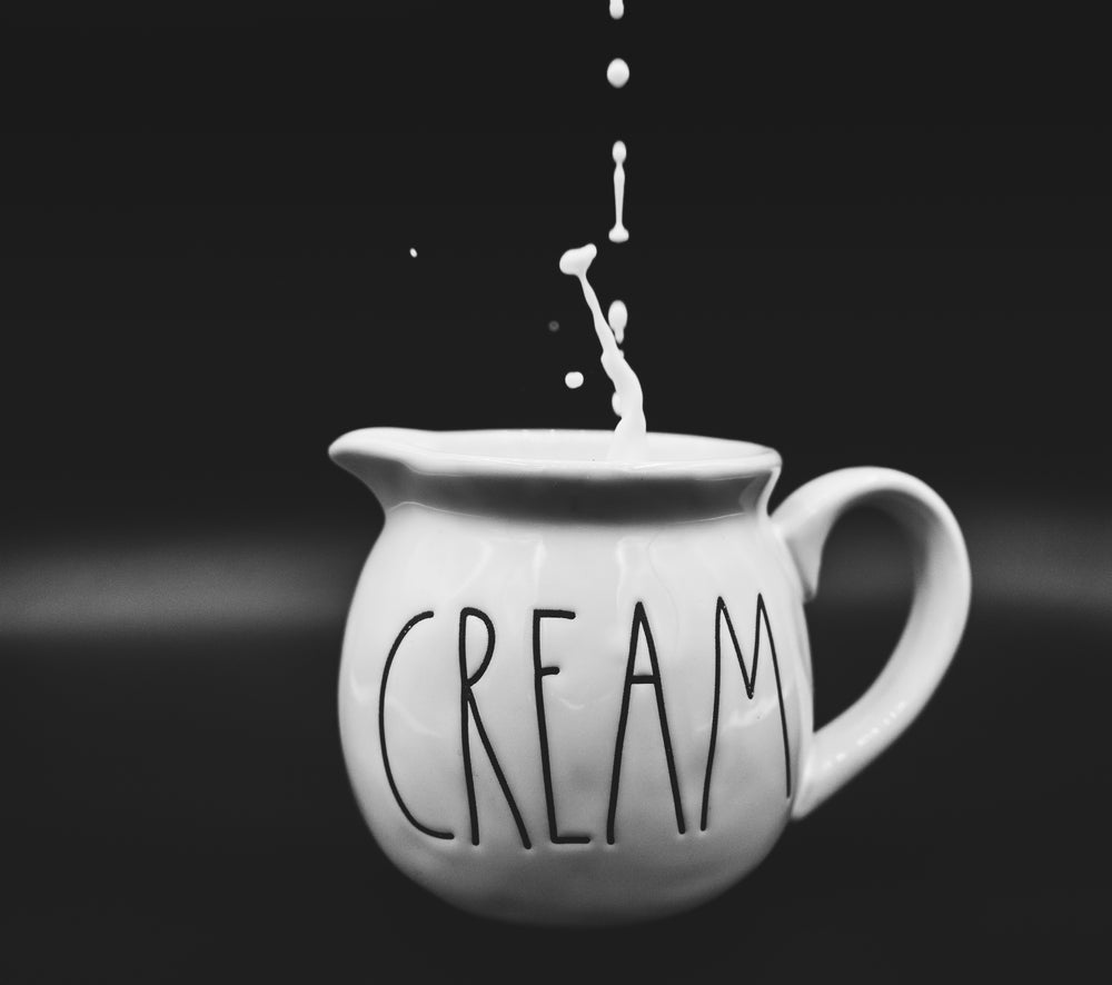 cream dripping into ceramic creamer