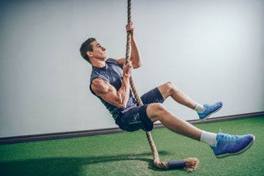 Crossfit rope climb exercise in fitness gym — Stock Photo