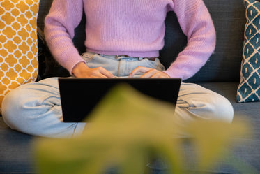 cross legged and typing on a laptop keyboard