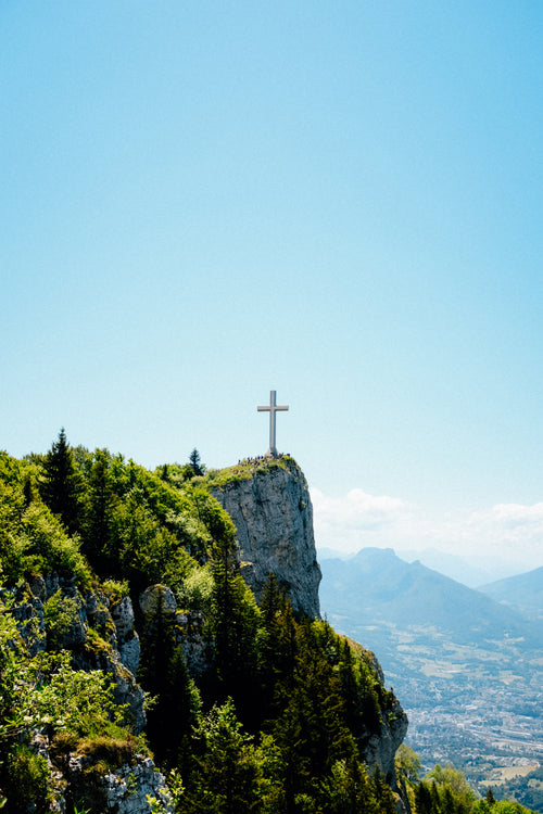 cross stands tall on a cliffside