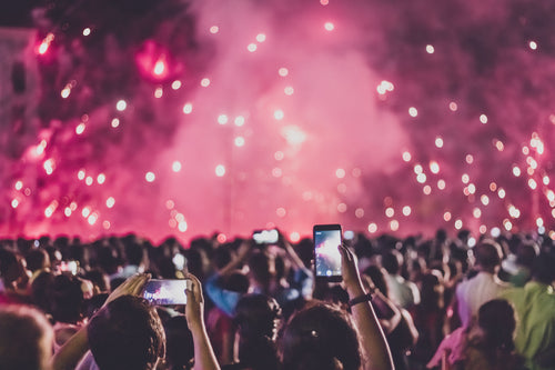 crowd capturing fireworks display on cell phone cameras