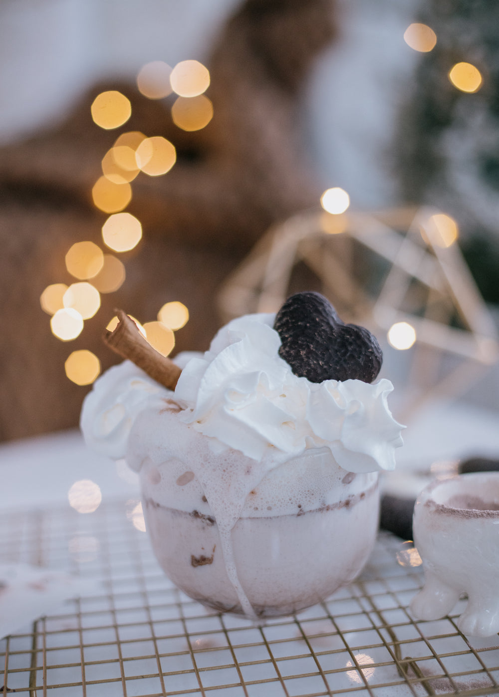 cup topped with whipped cream chocolate and a cinnamon stick