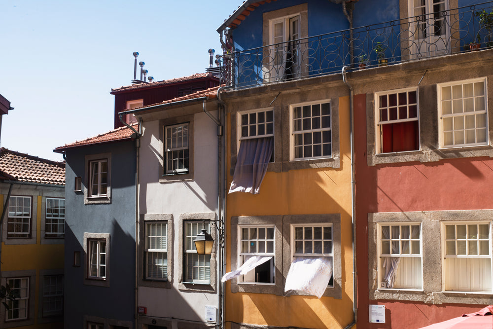 curtains flowing through windows of these colorful buildings