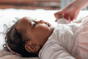 cute baby girl lying on bed looking up