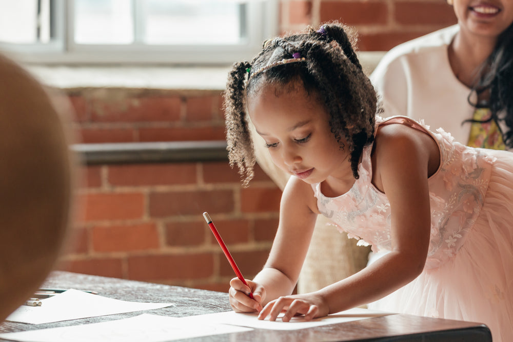 cute girl draws at table