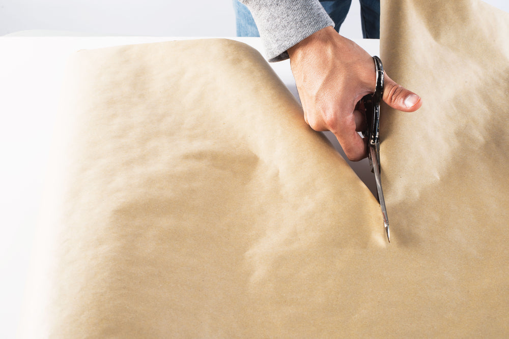 cutting kraft paper on a white table