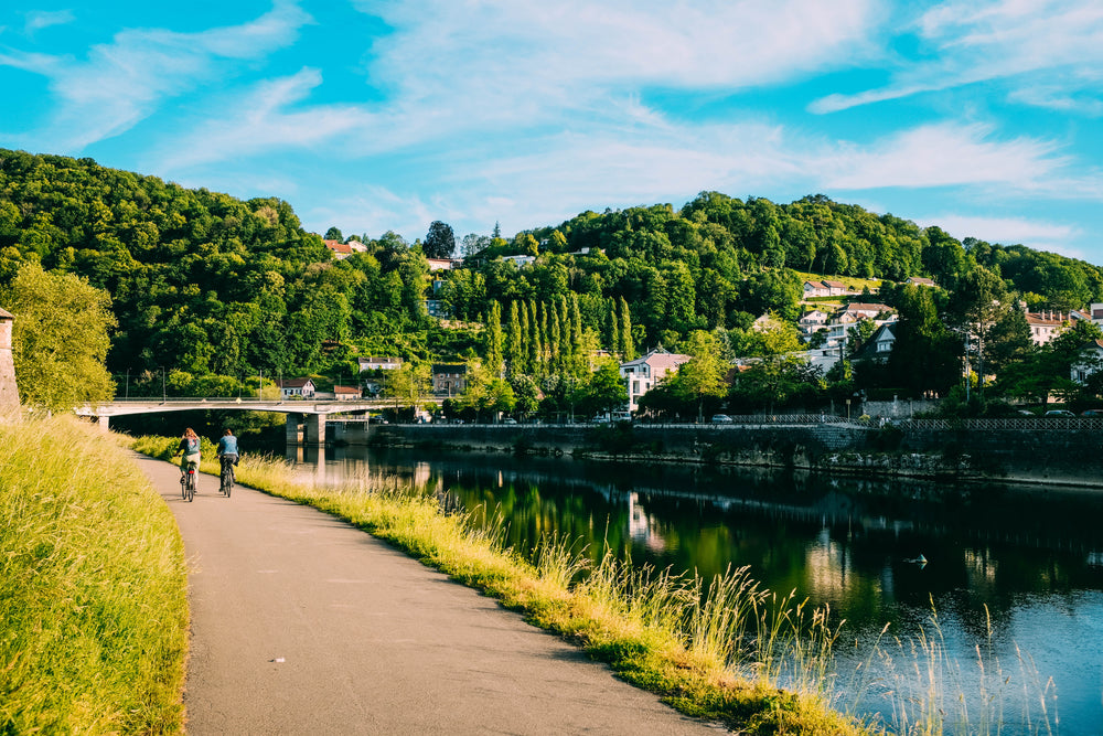 cyclists glide by the riverside