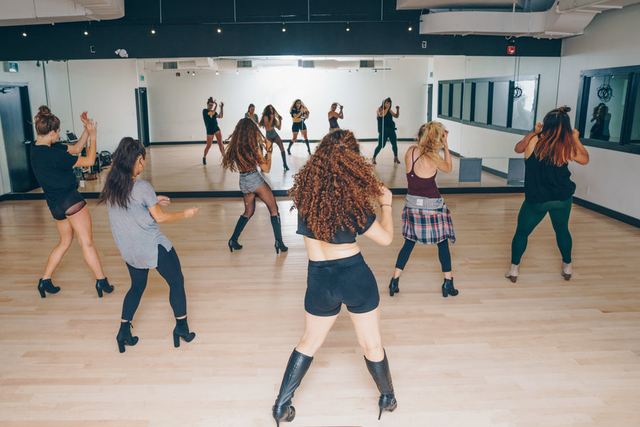 Grupo de personas en una clase de danza frente al espejo