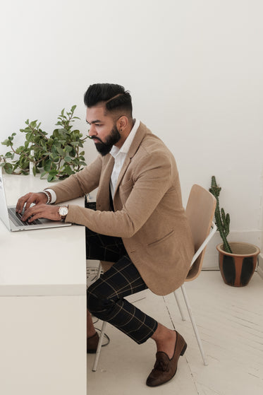 dapper store owner working on laptop