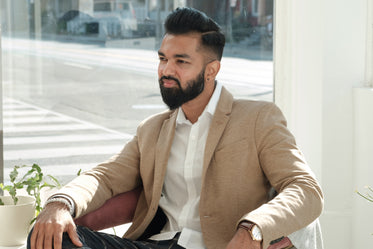 dapper young man sits in store window