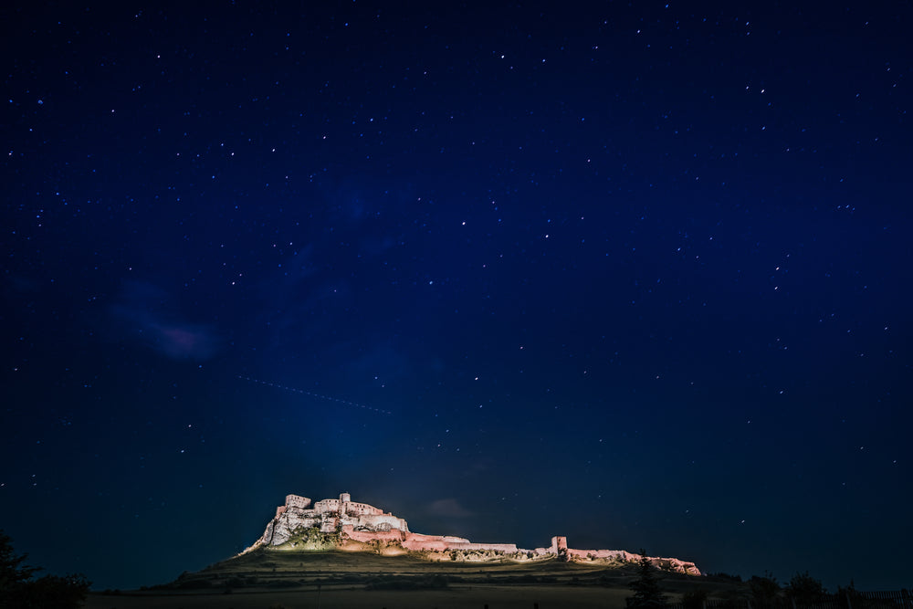 dark blue sky full of stars with a building lit up