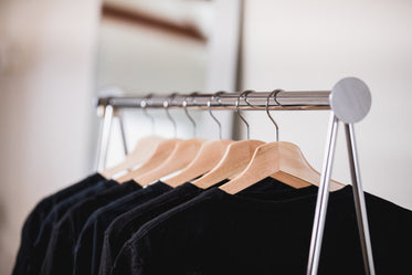 dark clothing on a shop rack with a mirror in the background