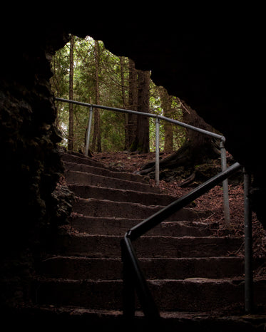 dark stony stairwell dips into cave