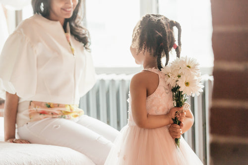 daughter about to suprise mom with flowers