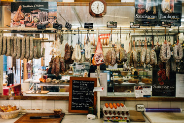 deli with cured meat on hooks and eggs on counter