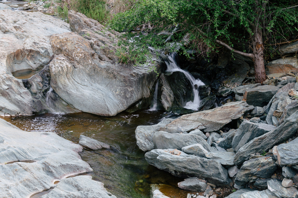 delicate waterfall beside rocky stream