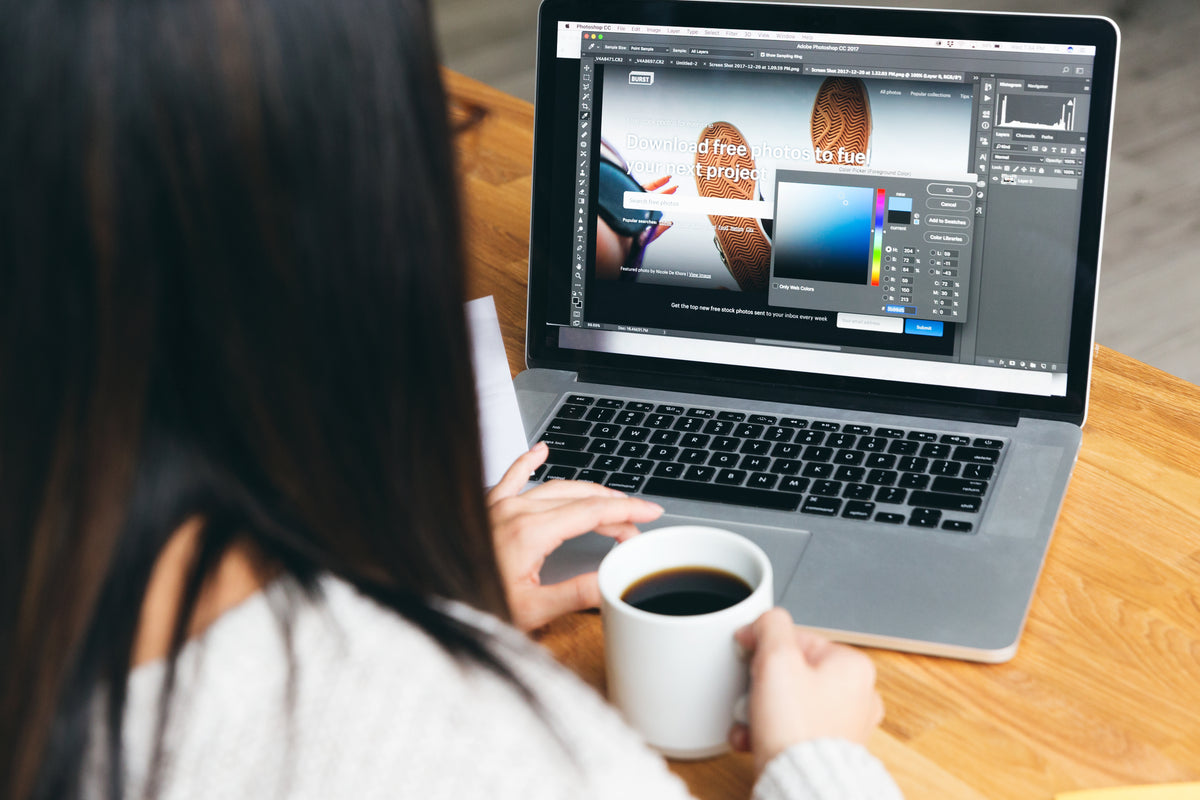 A web designer selecting colors for a website layout on a laptop, representing the creative process of using Midjourney for design inspiration