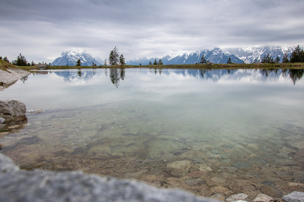 distant snowy mountains behind a clear blue lake