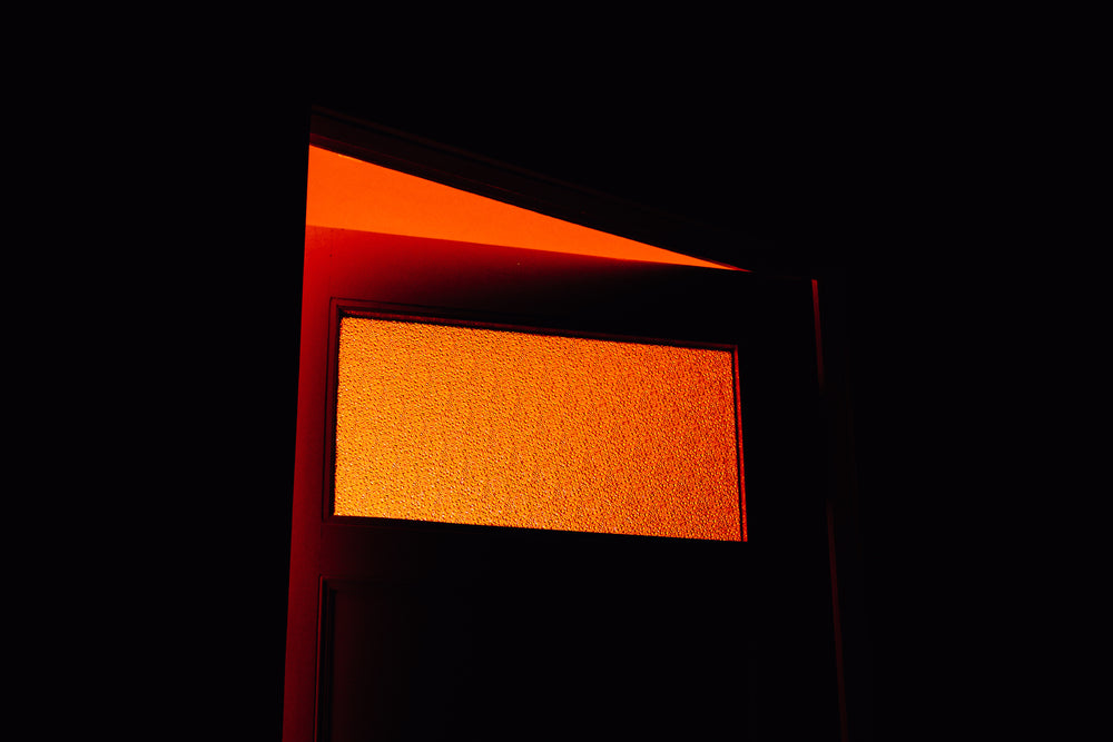 door with frosted window lets in orange sunlight