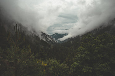 dramatic clouds roll over green mountain