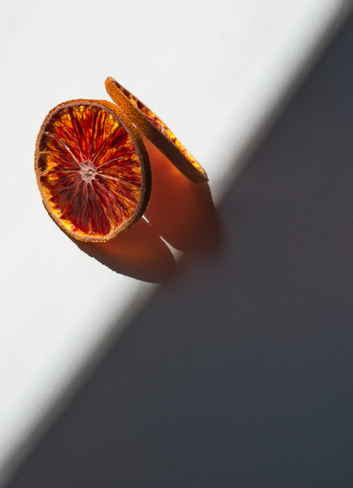 dried orange slices cast a orange shadow on white