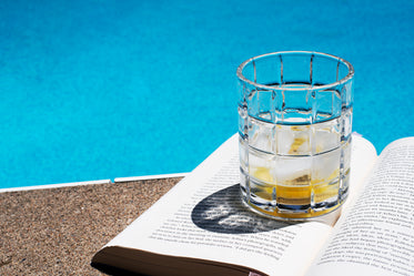 drink sat on a book by the pool