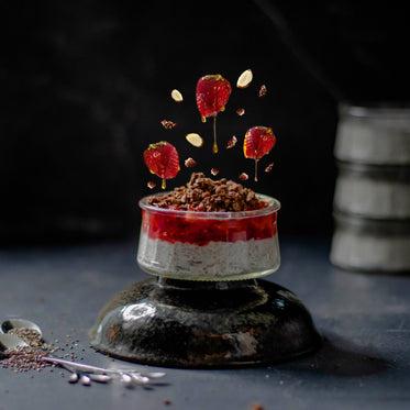 dripping strawberries and sliced almonds over dessert dish