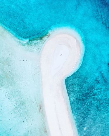 drone image of person on white sandy beach