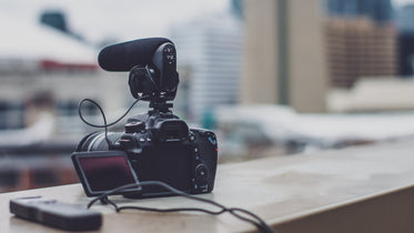 dslr with microphone on city ledge