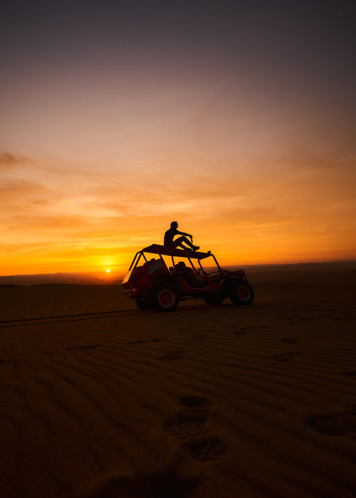 dune buggy in front of setting sun