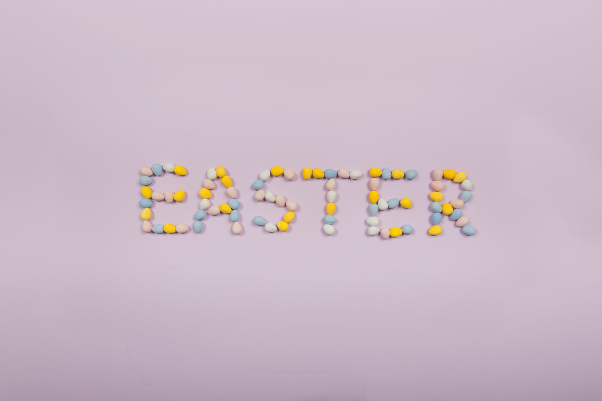 easter written in chocolate eggs on purple background
