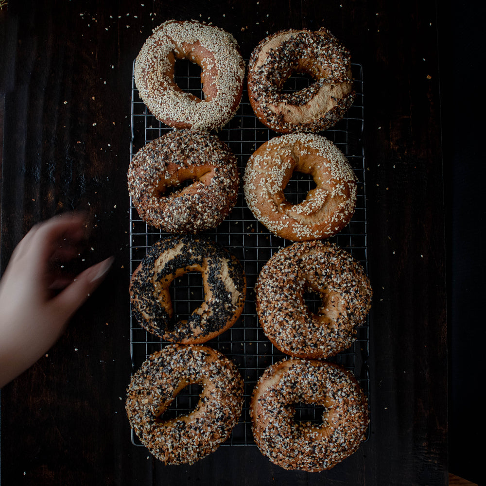 eight bagels on a silver metal cooling rack