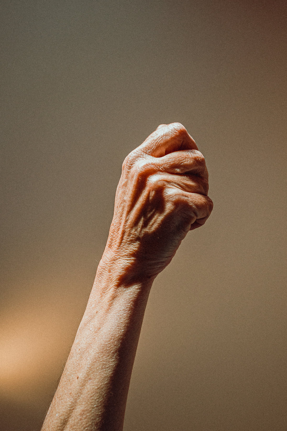 elderly person raises their fist