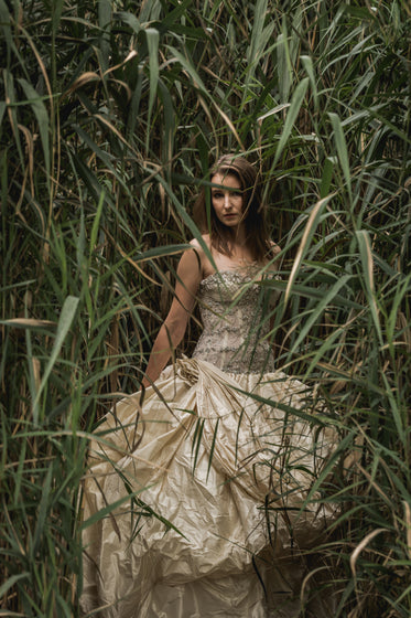 elegant woman standing in tall grass