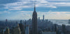empire state building with clouds in distance