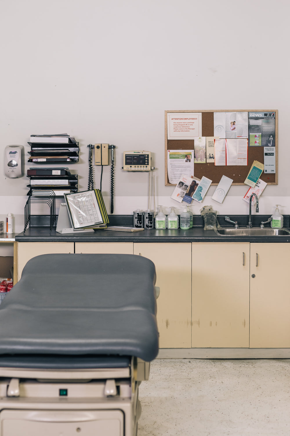 empty medical examining table sitting next to supplies