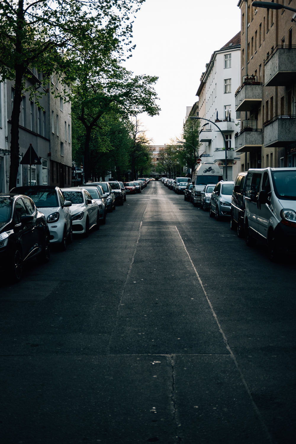 empty street at sunset full of parked cars