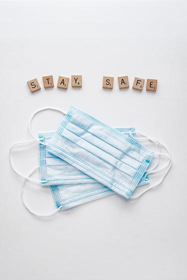 face masks and letter tiles spelling safe hands