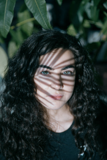 face of a person with a plant casting a shadow on them