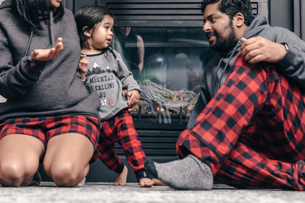 family lounging by the fireplace in pajamas