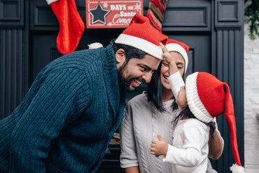 família experimentando chapéus de papai noel