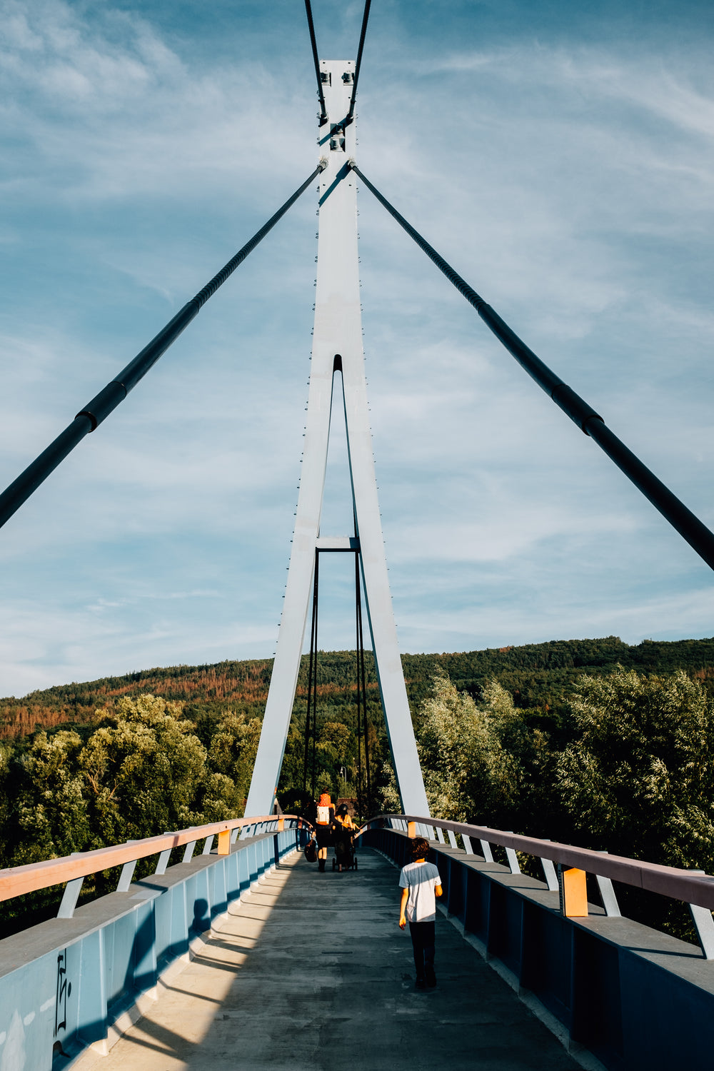 family walking on bridge toward forest