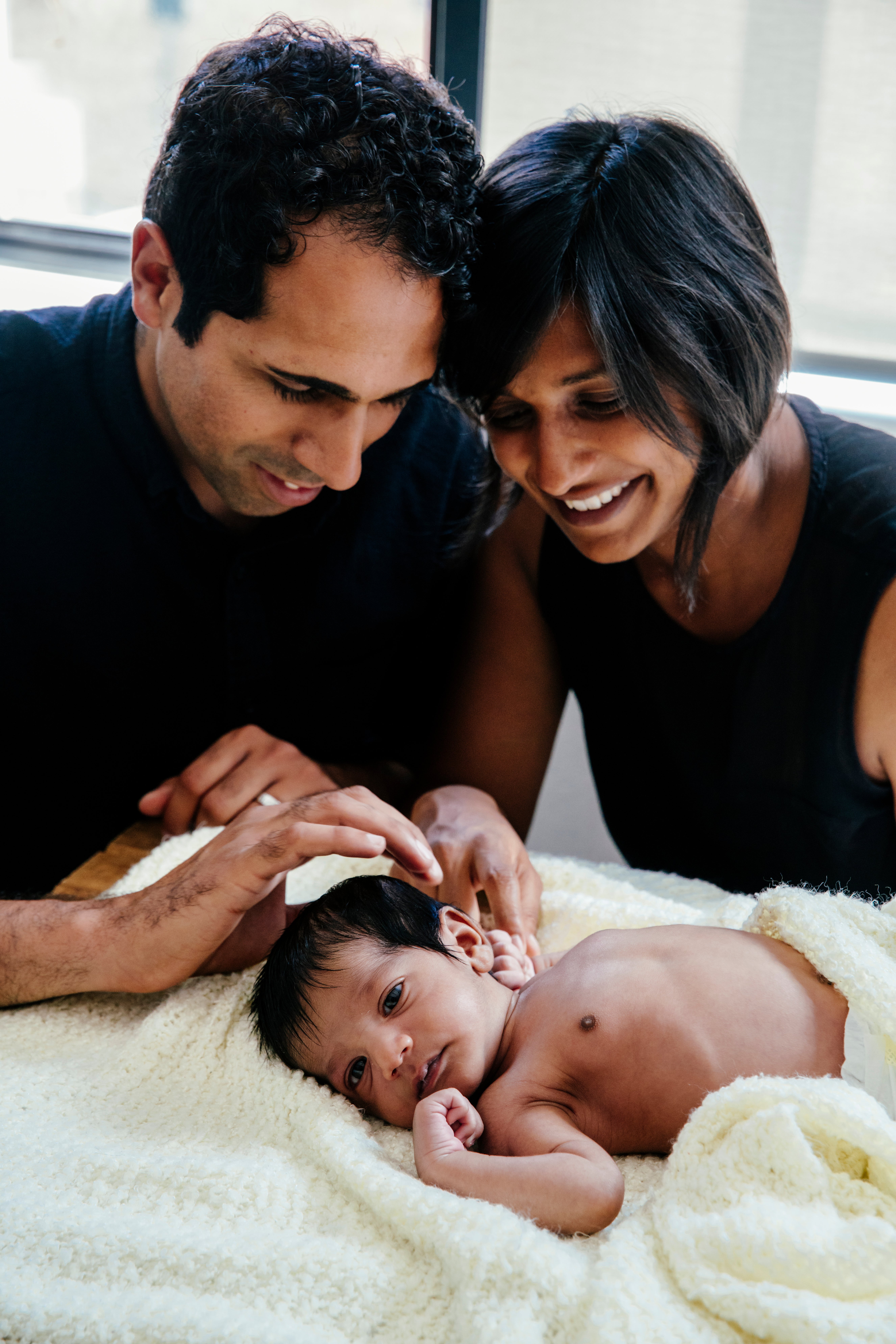 Parents spending a cozy family moment with their newborn baby