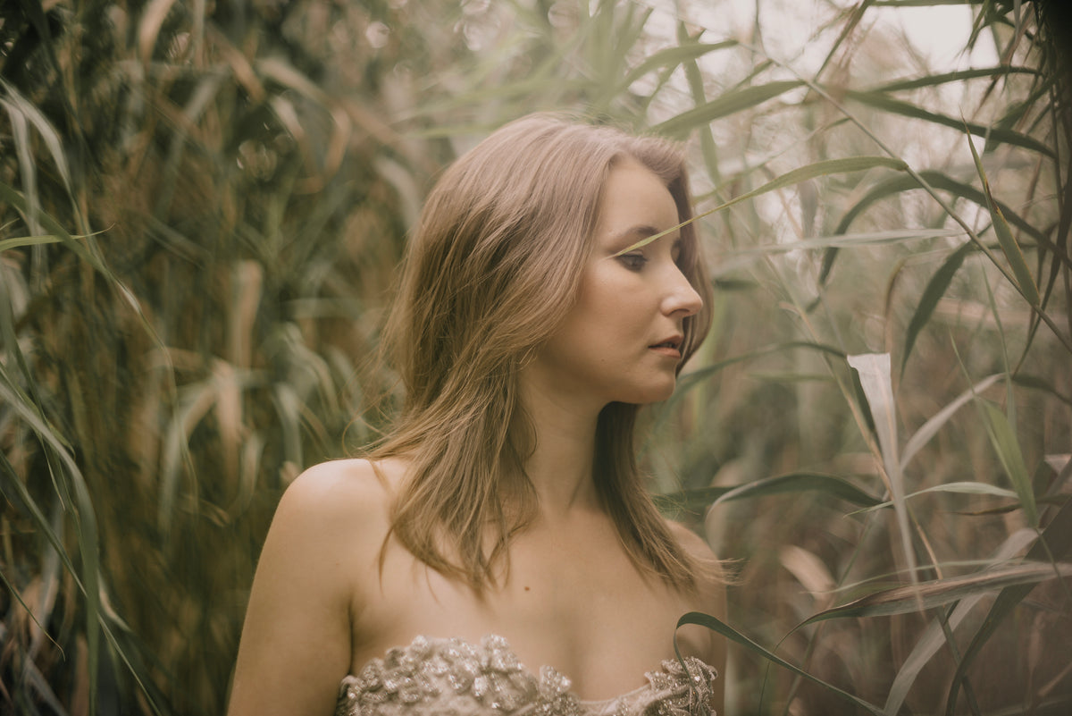 fashion model in beaded fashion and tall grass
