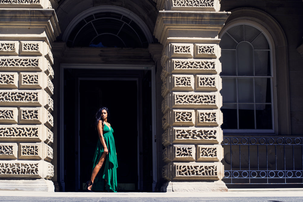 fashion model in green poses in archway